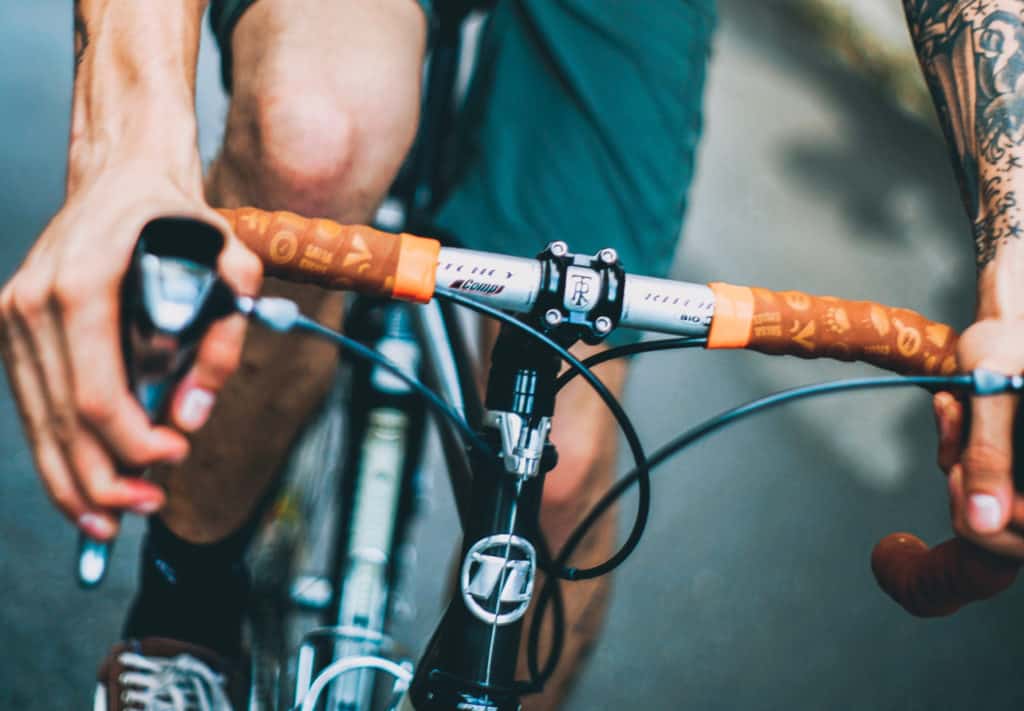 Homem pilota bicicleta com as mãos no freio