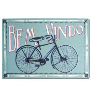 Um tapete azul claro com a ilustra&ccedil;&atilde;o de uma bicicleta preta e as palavras &ldquo;BEM VINDO&rdquo; em letras grandes e coloridas acima dela.