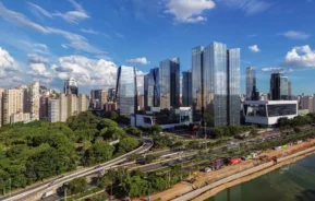 Imagem da vista urbana de São Paulo mostra prédios, vegetação e rio na marginal Pinheiros em um dia de céu azul para ilustrar matéria sobre os bairros mais caros de SP