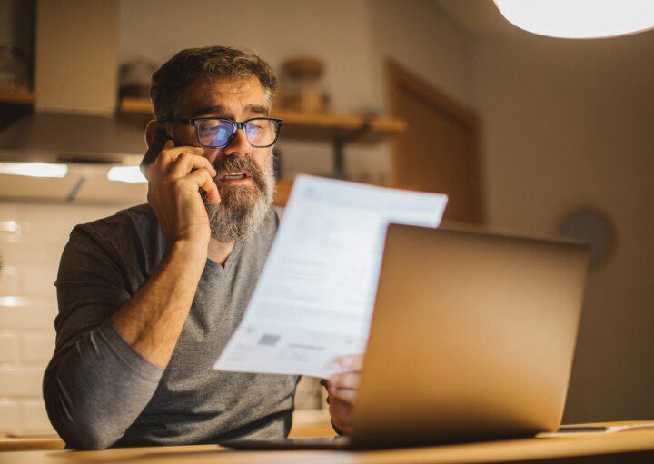 Em matéria que fala sobre aumento do gás, um homem está sentado com o telefone no ouvido e com um papel na mão, simulando o ato de estar falando sobre uma conta.