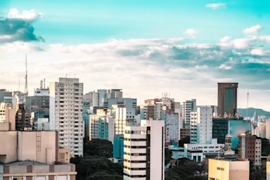 Imagem da vista aérea do bairro Jardim Paulista, em São Paulo, mostra vários edifícios altos sob um céu azul parcialmente nublado