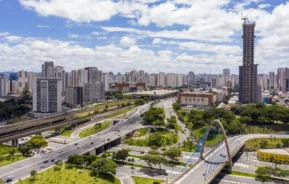 Imagem da vista aérea da cidade de São Paulo mostra avenidas, prédios, carros e vegetação em um dia de céu azul para ilustrar matéria sobre as melhores cidades para morar no Brasil