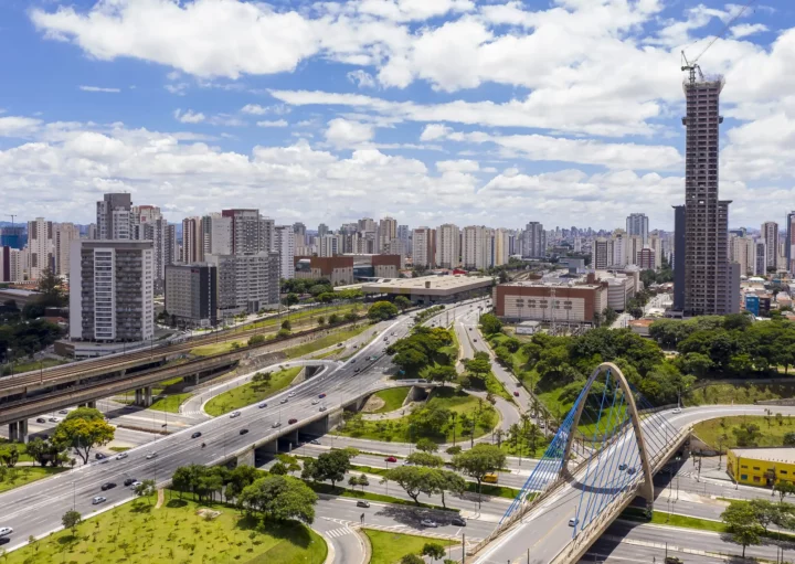 Imagem da vista aérea da cidade de São Paulo mostra avenidas, prédios, carros e vegetação em um dia de céu azul para ilustrar matéria sobre as melhores cidades para morar no Brasil