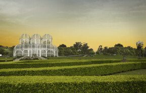 Foto que ilustra matéria sobre morar em Curitiba mostra a icônica estufa de vidro do Jardim Botânico da cidade ao entardecer.