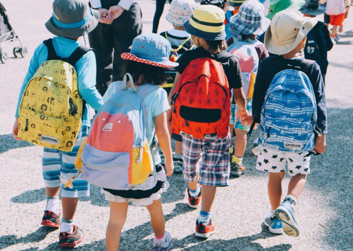 grupo de crianças andando na rua, usando mochilas escolares e roupas coloridas — capa do conteúdo sobre as melhores escolas particulares do Rio de Janeiro