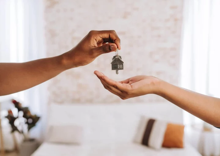 Imagem de um agente imobiliário entregando a uma pessoa as chaves da sua nova casa para ilustrar matéria sobre como funciona o seguro fiança