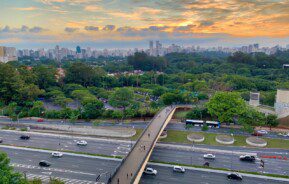 Vista panorâmica de uma ponte sobre uma rodovia que permite atravessar para um parque em Guarulhos.