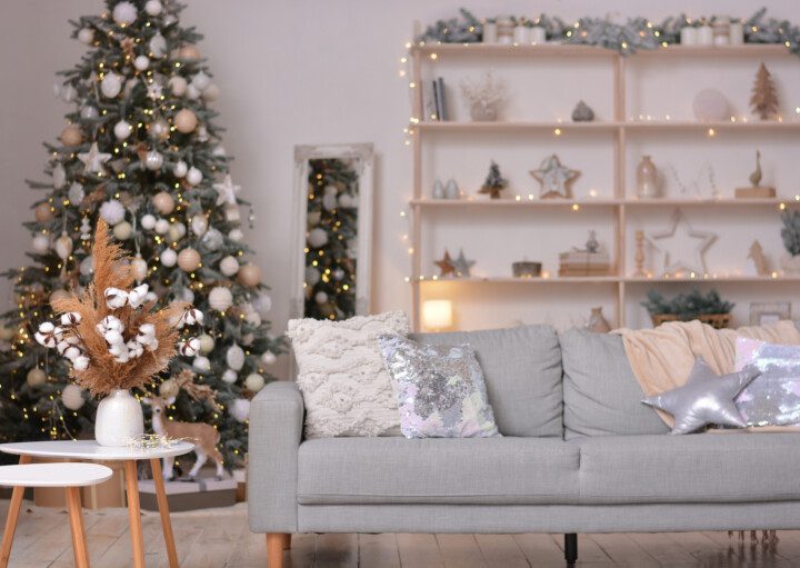 Sala de estar moderna decorada para o Natal em tons neutros com árvore e enfeites.