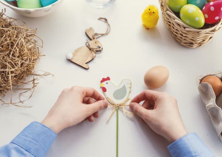 Ideias de decoração de páscoa: duas mãos fazendo uma decoração artesanal