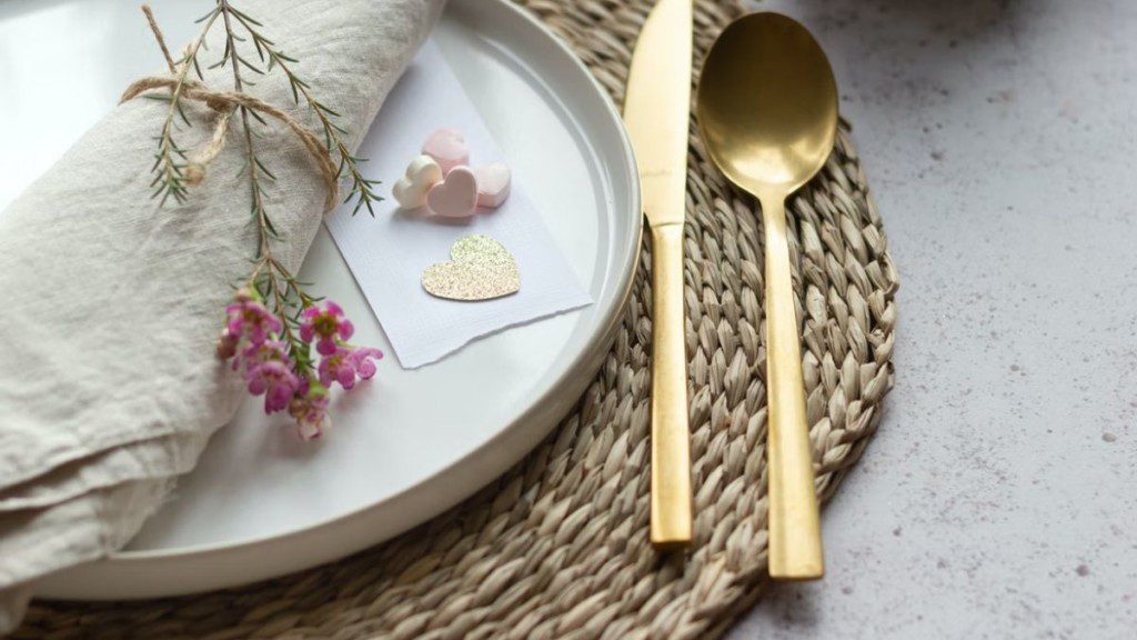 prato com jogo americano redondo embaixo e mesa posta com cores em tons pasteis