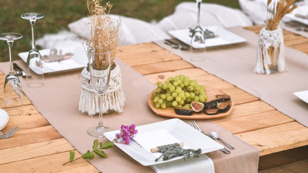 mesa de madeira, em estilo rústico, posta com decoração para jantar de noivado