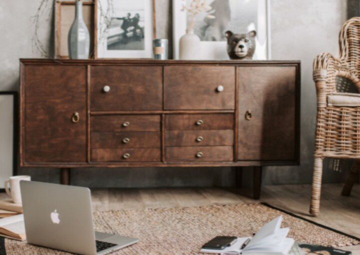 cômodo com móveis de madeira, notebook, tapete e toda uma decoração rústica