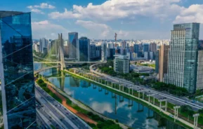 Imagem da Ponte Estaiada e da Marginal Pinheiros em um dia de céu azul para ilustrar matéria sobre a Zona Oeste de São Paulo