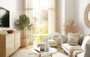 vista de uma sala minimalista, com iluminação natural entrando pela janela ampla, sofá branco, carpete, mesa de centro e televisão de tela plana na parede