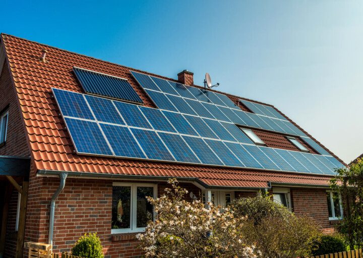 Foto que ilustra matéria sobre casas sustentáveis mostra uma casa vista de lado, com detalhe para o seu telhado quase que totalmente coberto por painéis de captação da luz solar para transformação em energia fotovoltaica.