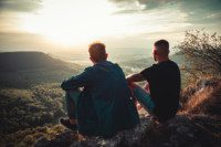 Foto que ilustra quiz de casal para o Dia dos Namorados mostra um casal vendo o por do sol de cima de uma montanha, representando um casal que gosta de por do sol