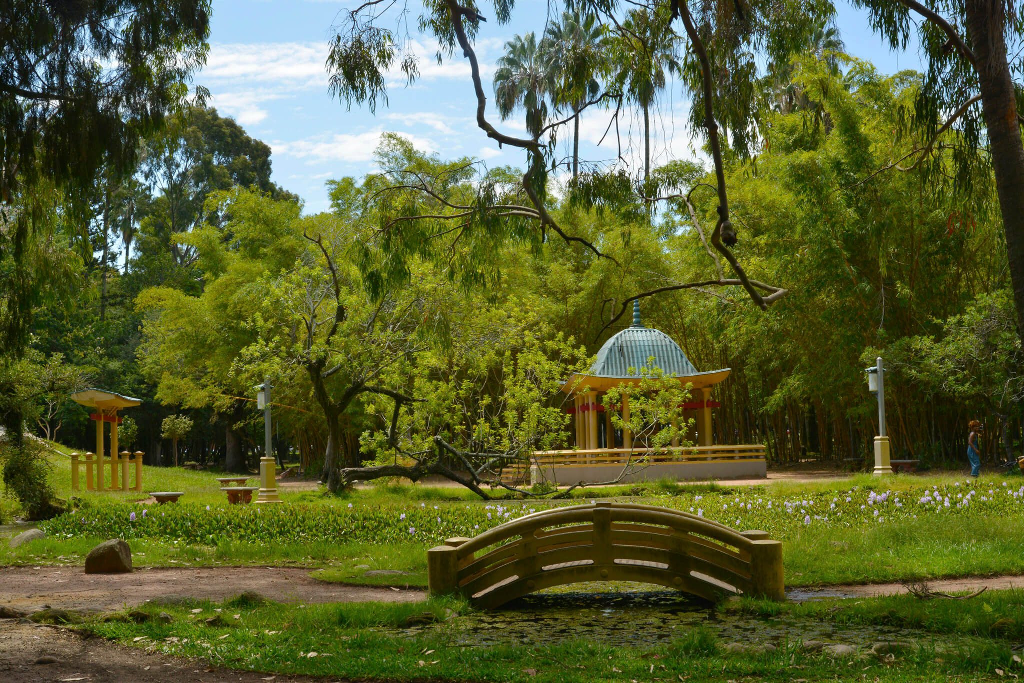 Foto que ilustra matéria sobre o que fazer em porto alegre mostra um recanto do Parque Farroupilha, com uma pequena ponte ao centro, um coreto ao fundo e muitas árvores no entorno.