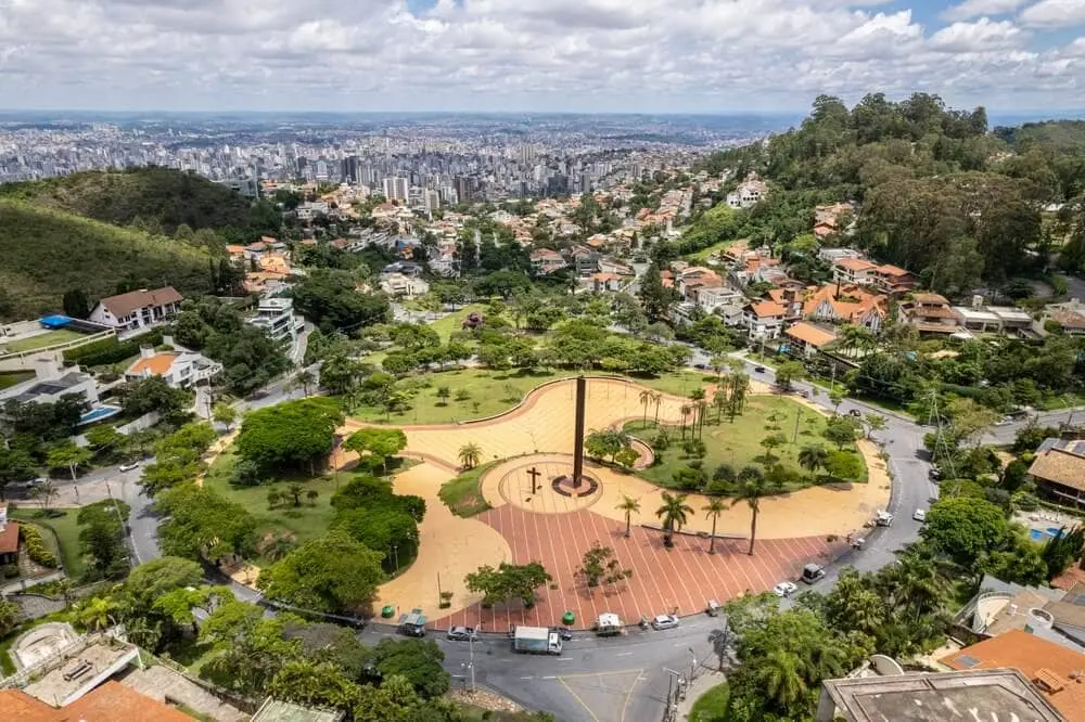 Imagem aérea da Praça do Papa, em Belo Horizonte, mostra estrutura do atrativo, vegetação local e prédios ao fundo para ilustrar matéria sobre bairros em bh para morar
