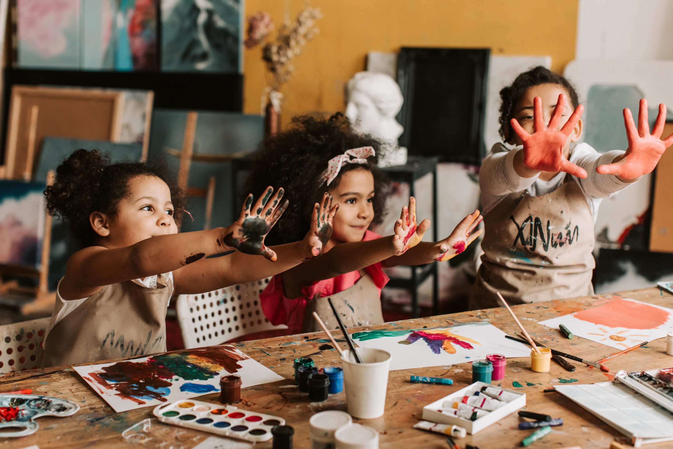 Imagem de um casal pintando a parede da casa com tinta de cor verde.