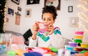 Imagem de uma menina brincando com slime.