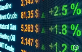 Display digital mostrando preços e aumentos percentuais de commodities energéticas, como gasolina, petróleo Brent, gás natural, óleo para aquecimento e petróleo WTI, com setas verdes indicando valores crescentes.