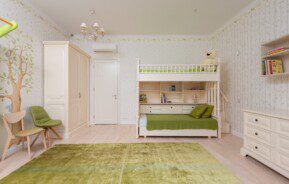 A foto mostra um exemplo de quarto infantil retrô. Com tons de verde e bege, o quarto é composto por um tapete, duas cadeiras, um beliche, uma cômoda e um guarda-roupas. Todos com design retrô.
