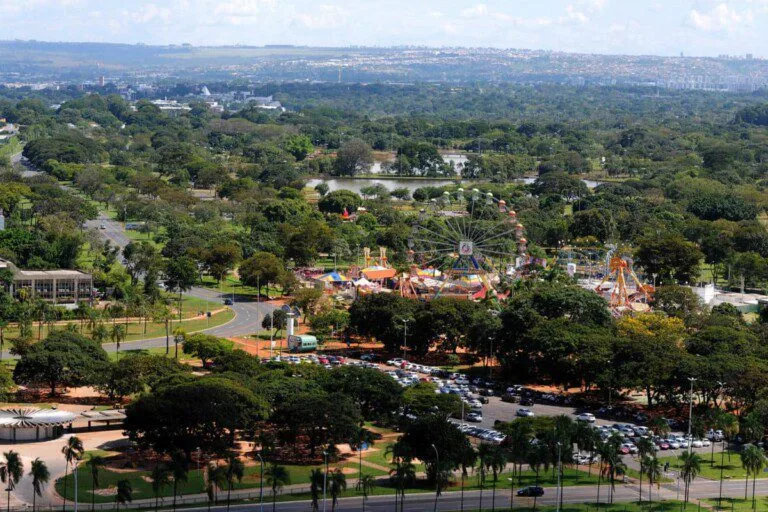 Imagem da vista aérea do Parque da Cidade Dona Sarah Kubitschek mostra vegetação do parque, o Nicolândia, estacionamento para carros e um lago artificial para ilustrar matéria sobre o que fazer em Brasília ao ar livre