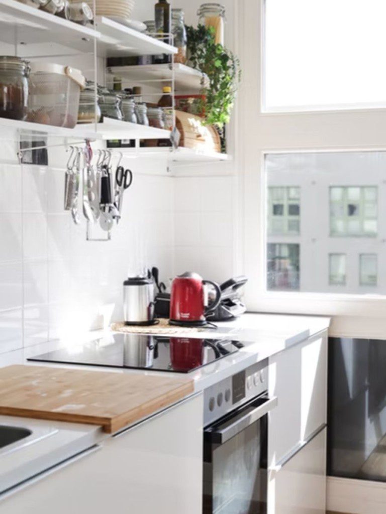 ambiente com fogão pia e armários bem iluminado