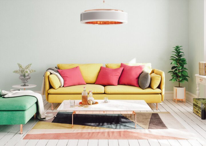 A foto mostra um exemplo de decoração retrô em uma sala de estar. Na imagem há: sofá, poltrona, mesa de centro, luminária de teto, tapete e plantas.
