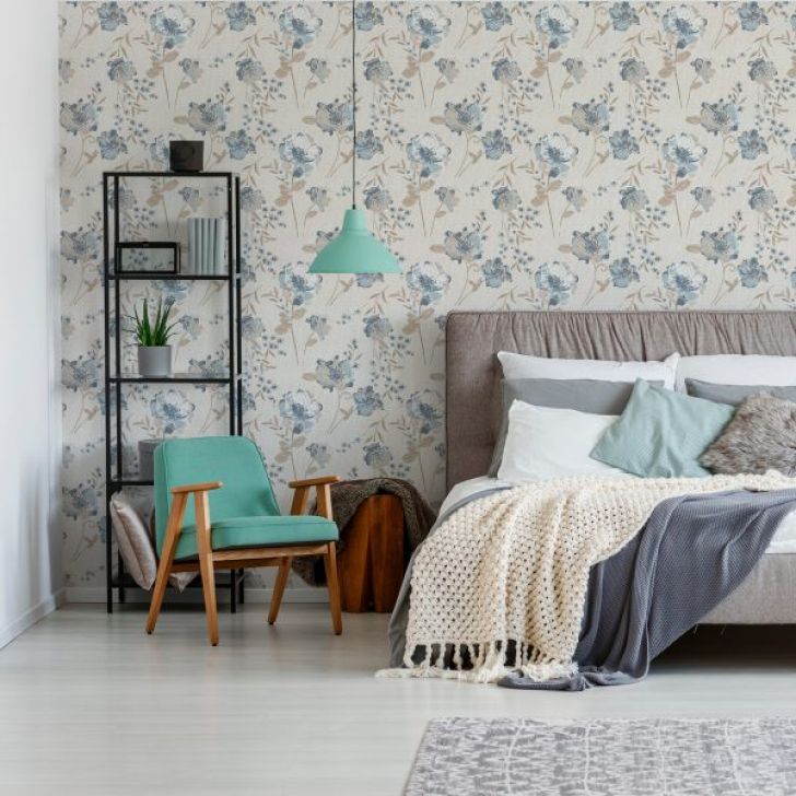 A foto mostra um exemplo de decoração retrô no quarto de casal com poltrona, estante e cama repleta de almofadas.