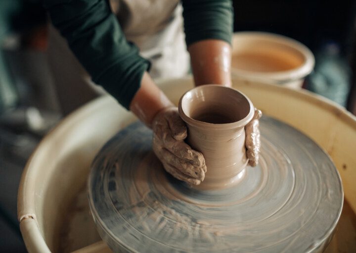 Imagem de uma mulher pintando um vaso de cerâmica para ilustrar conteúdo sobre como fazer vaso de cerâmica.