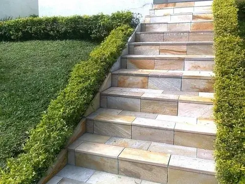 Foto que ilustra matéria sobre tipos de piso mostra uma escada em área externa revestida com Pedra São Tomé.