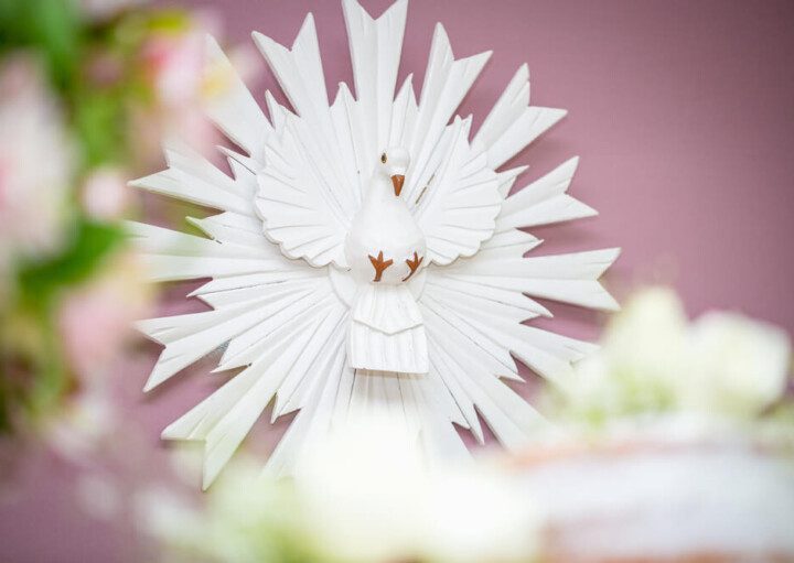 Foto que ilustra matéria sobre decoração para batizado mostra uma imagem do Divino Espírito Santo, representado por uma pomba branca.