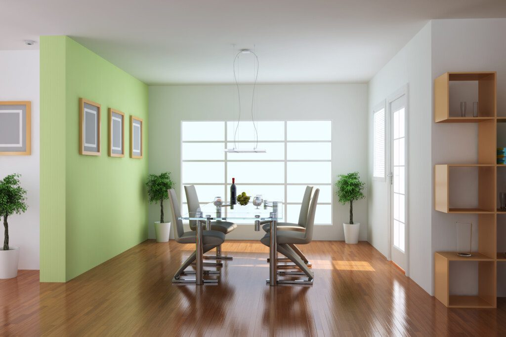 Sala de jantar com mesa e cadeiras em metal, no estilo moderno. Há também plantas decorando o ambiente.