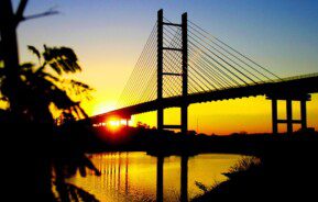 Foto que ilustra matéria sobre bairros de Hortolândia mostra o por do sol atrás de uma ponte estaiada.