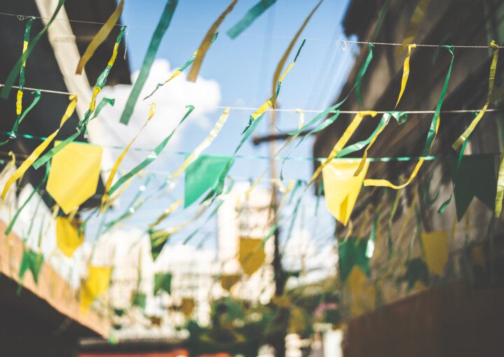 Decoração de rua com bandeirinhas em verde e amarelo para assistir aos jogos do Brasil.