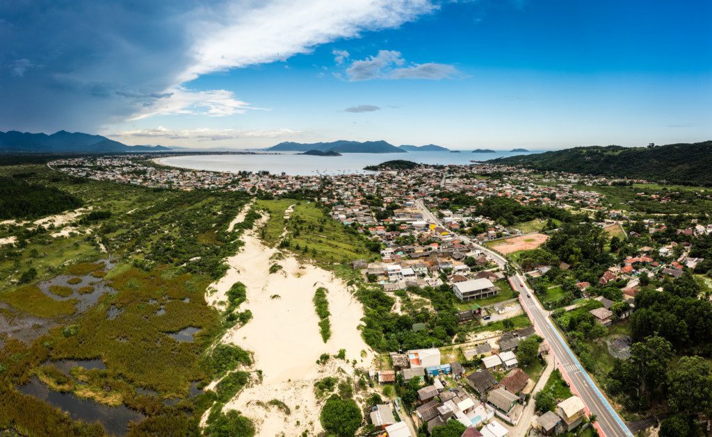 Imagem que ilustra matéria sobre como é morar em Palhoça mostra uma visão panorâmica da Enseada da Pinheira.