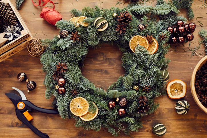 Guirlanda de Natal decorada com fatias de laranja, verdes e pequenas esferas.