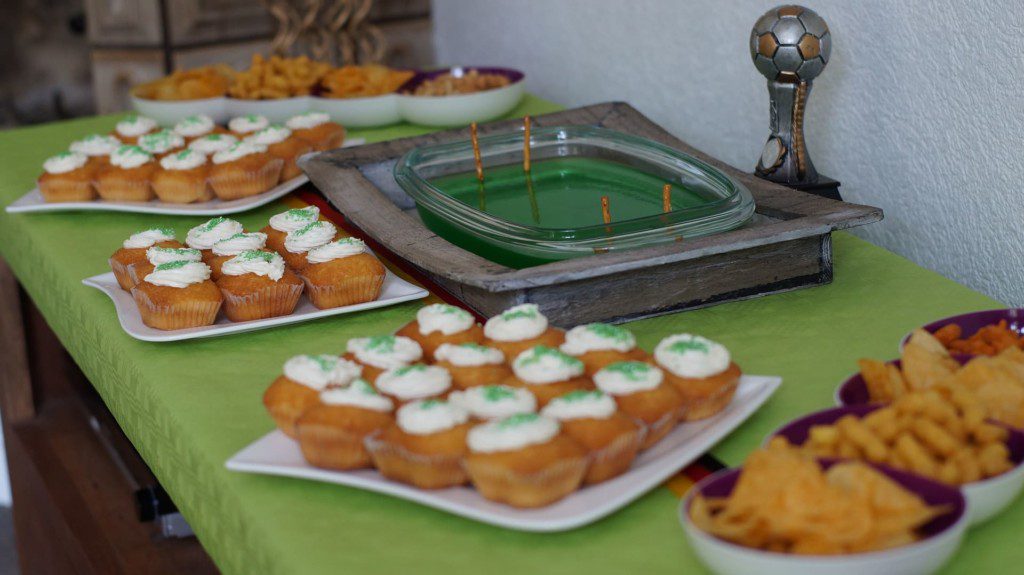 Mesa com decoração e buffet com as cores da seleção brasileira de futebol.