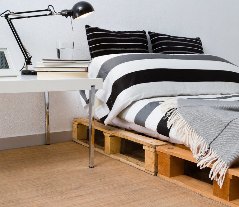 Sem grandes investimentos, os paletes posicionados lado a lado servem de estrado da cama