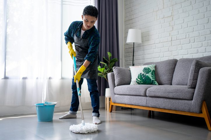 Imagem de uma homem limpando o chão da sala com um Mop modelo 360.