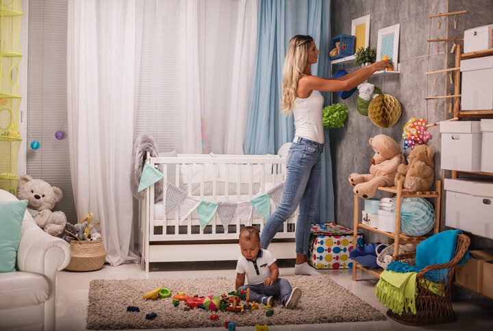 Imagem de uma mãe organizando o quarto do filho.