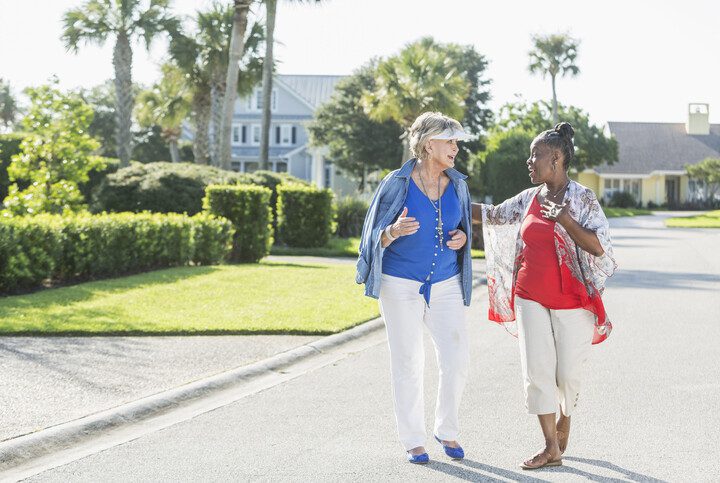 Imagem de duas mulheres caminhando e conversando no condomínio.