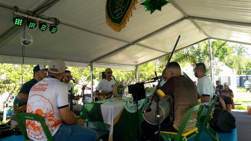 Foto que ilustra matéria sobre o Terminal Grajaú mostra homens tocando e cantando em uma roda de samba.