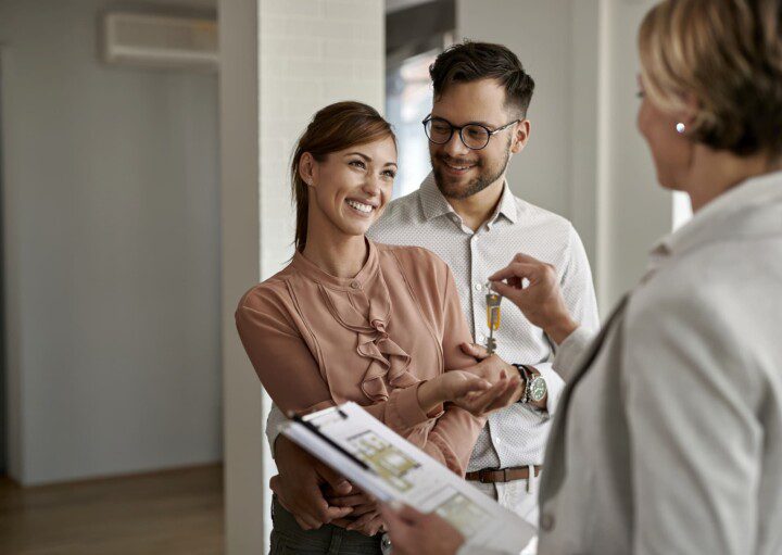 Casal recebe a chave do seu novo apartamento. Imagem disponível em Getty Images.