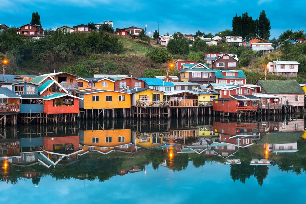 Imagem ilustrando modelo de casas com diferentes cores, de construção palafita.