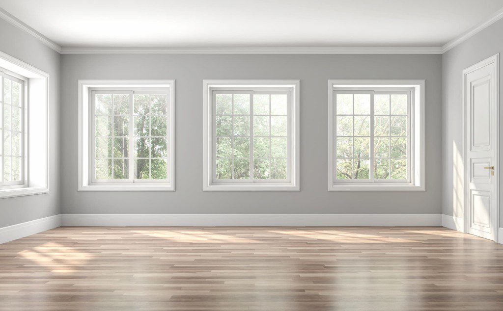 Sala vazia, com moldura de gesso nas janelas e roda teto. Imagem disponível em Getty Images.