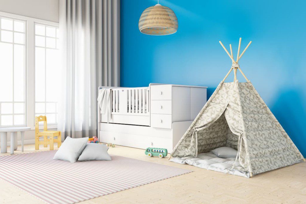 Quarto de bebe moderno, com clores claras e uma tenda armada. Imagem disponível em Getty Images.