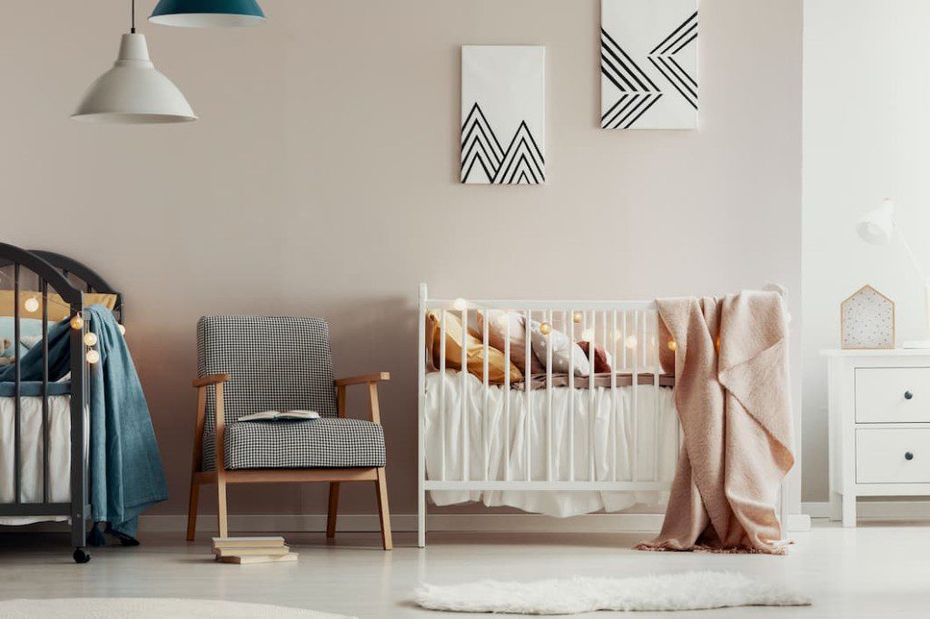 Quarto de bebe com luminária moderna. Imagem disponível em Getty Images.