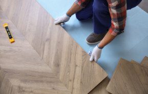 Homem instalando um piso laminado.